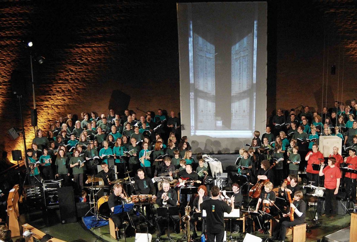 Blick auf die Mitwirkenden beim Oratorium "Petrus und der Hahn" 2015 in Heilige Familie Düsseldorf-Stockum. Im Hintergrund zeigt die 6 Meter hohe Videowand die sich öffnende Tür der Lateran-Basilika
