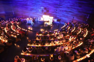 Innenraum der katholischen Kirche Heilige Familie in Düsseldorf-Stockum während der Lesungen in der Osternacht - die Illumination an der Wand hinter dem Altar zeigt passend zur "Erschaffung der Welt" Wasser